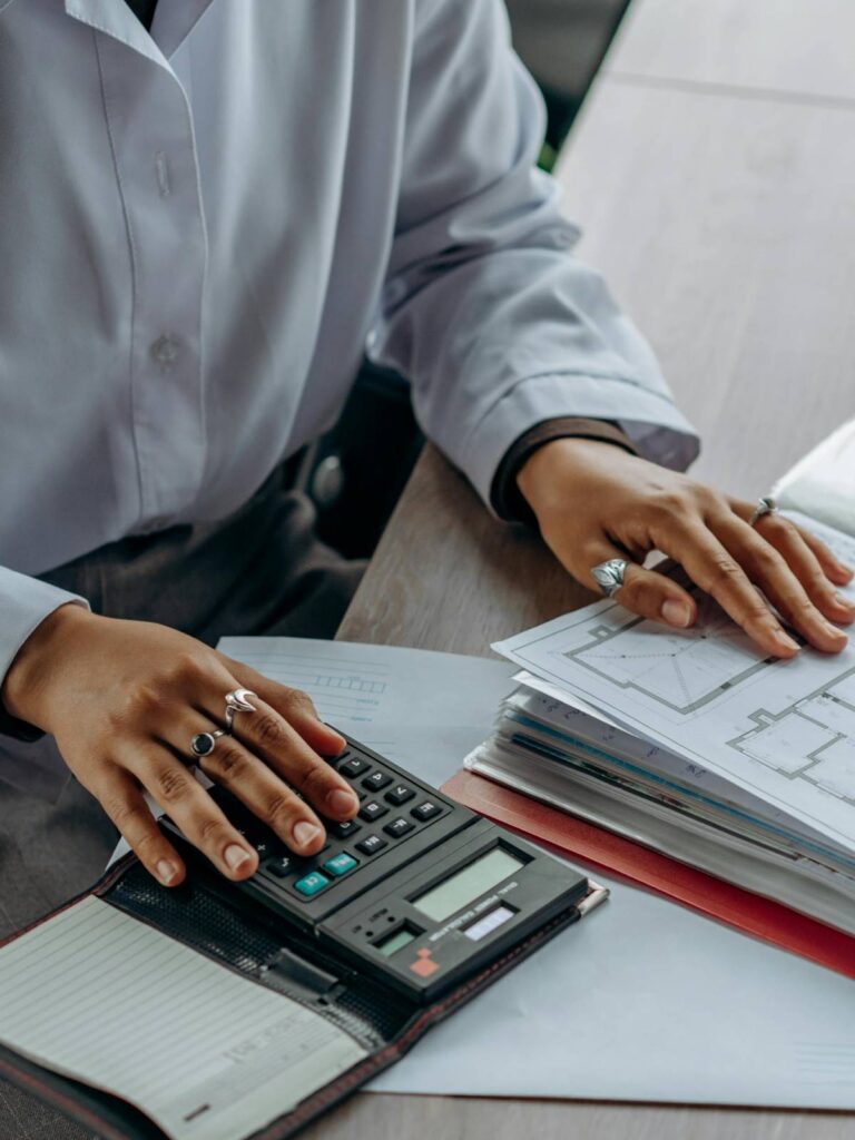 Corporate Tax 7 Architect or Designer Working with Plans and Calculator in Office
