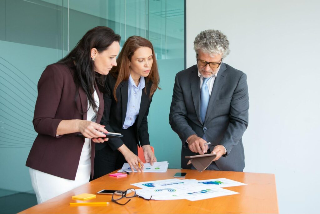 The team Audit in Business reviews data on a digital tablet.
