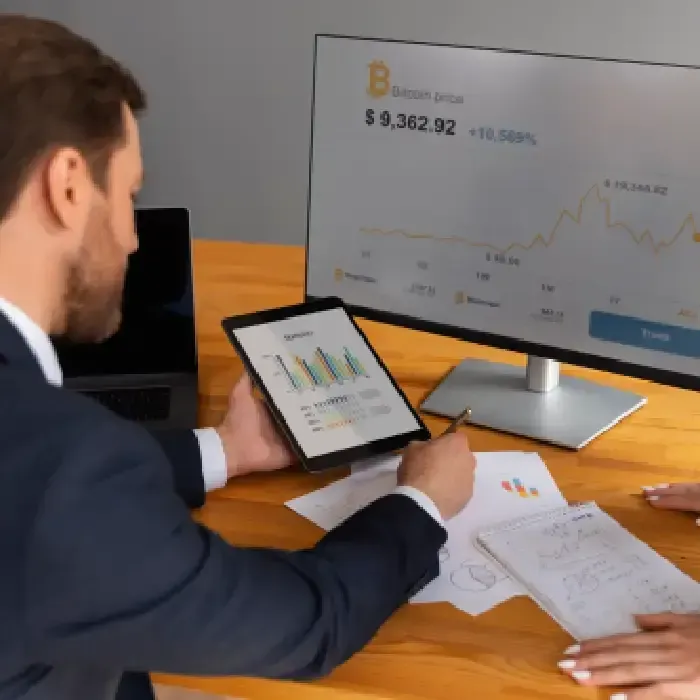 Businessman analyzing bitcoin price data on tablet.