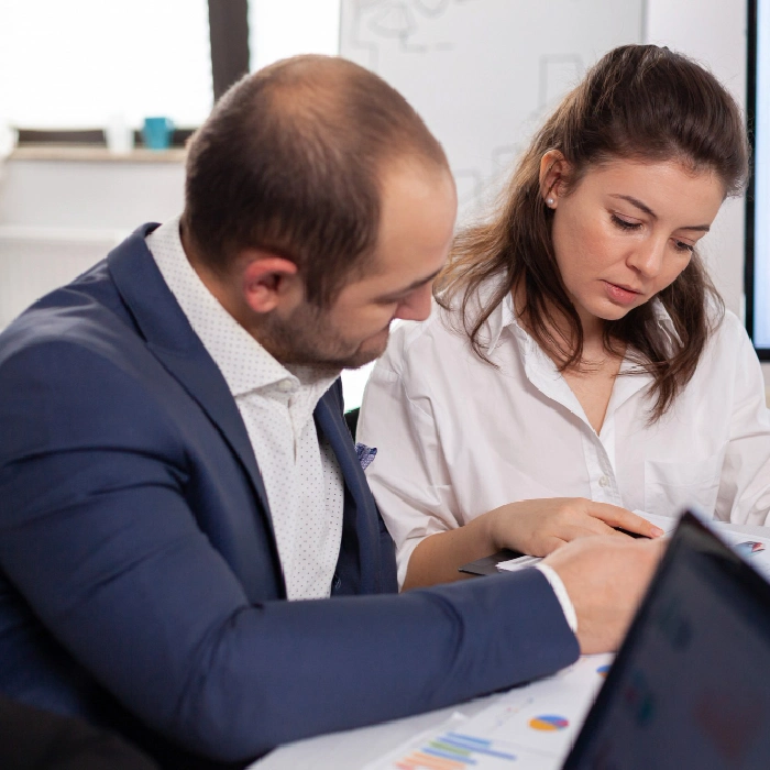 Business professionals analyzing year-end financial statements together.