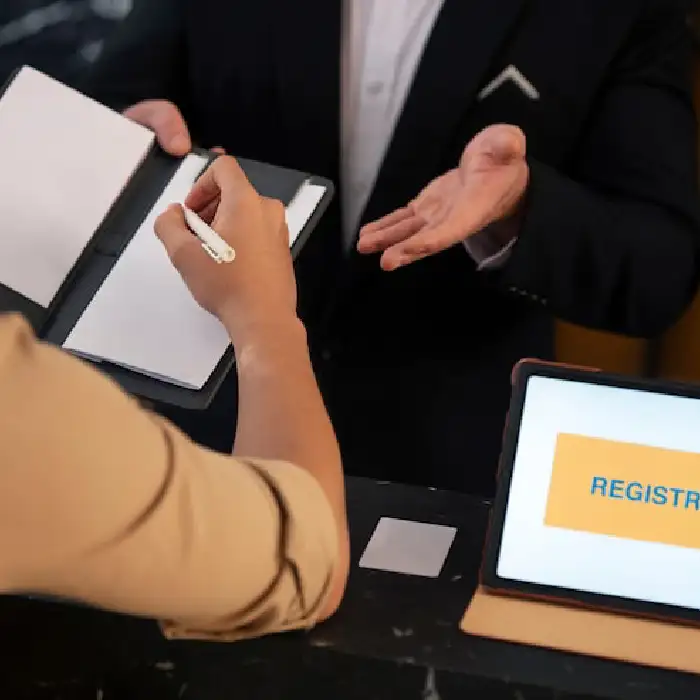 Customer signing documents at a registration counter.