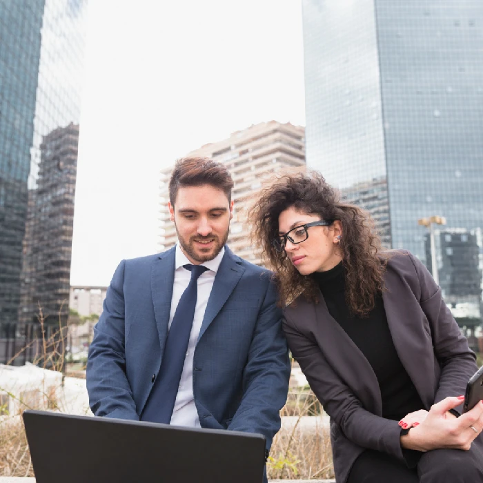 Business professionals reviewing information on a laptop in a corporate district.