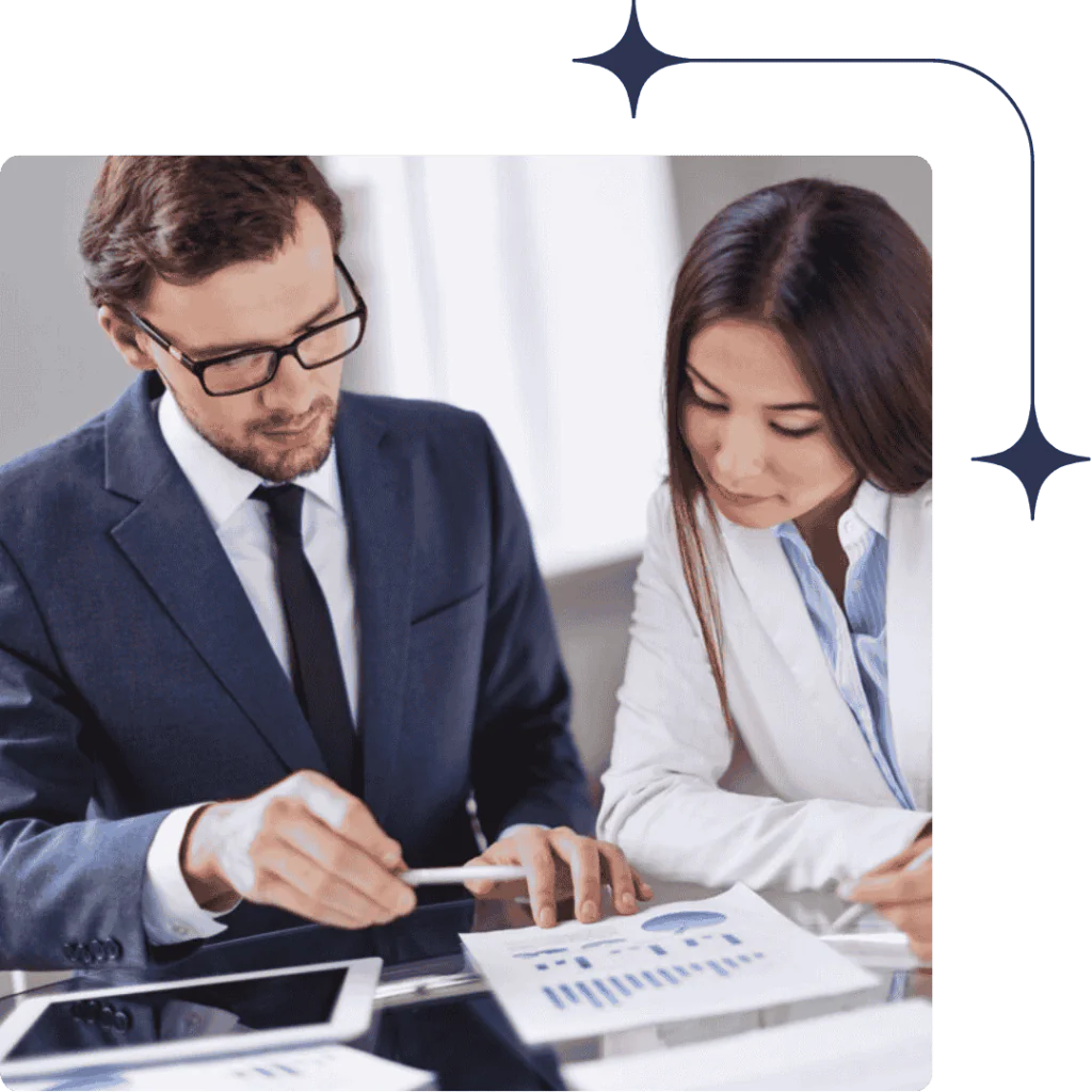 Statutory Audit 4 Two professionals collaborating in a bright office, reviewing financial charts and data on a laptop and paper reports.