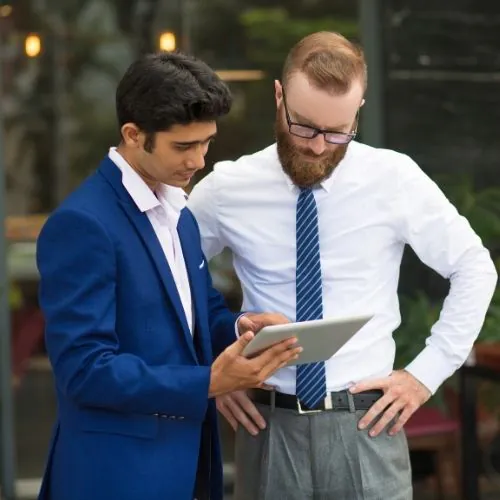 Business professionals discussing documents Capital Plus UAE